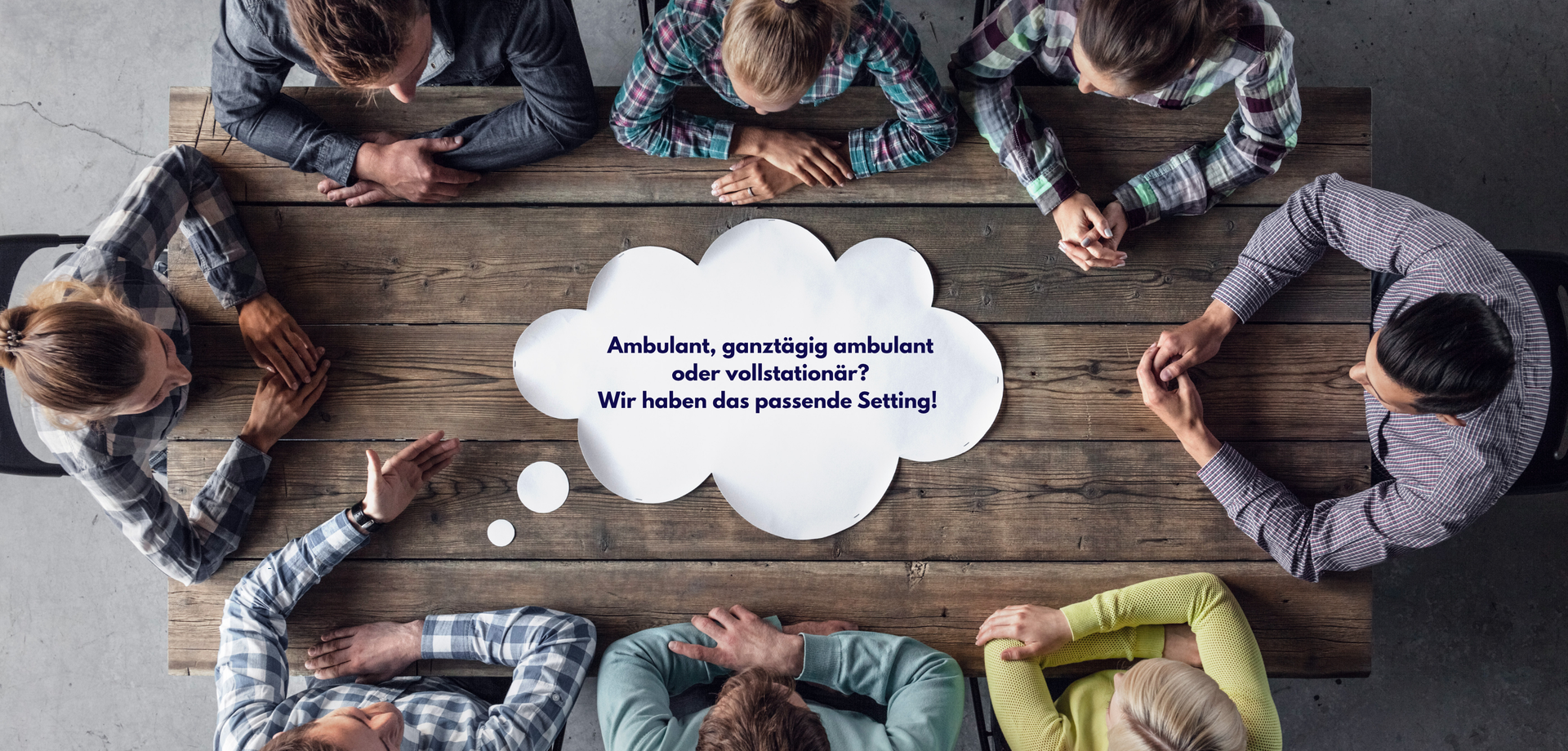 Personen sitzen gemeinsam am Tisch ud unterhalten sich.